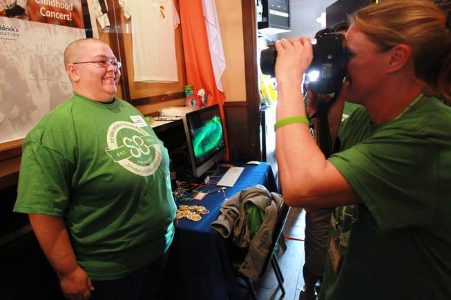 Jamie Poltrock has her photo taken with her freshly shorn head during the St. Baldrick's head shaving fundraiser for cancer Saturday, March 1, 2014 at McMillan's Irish Pub.